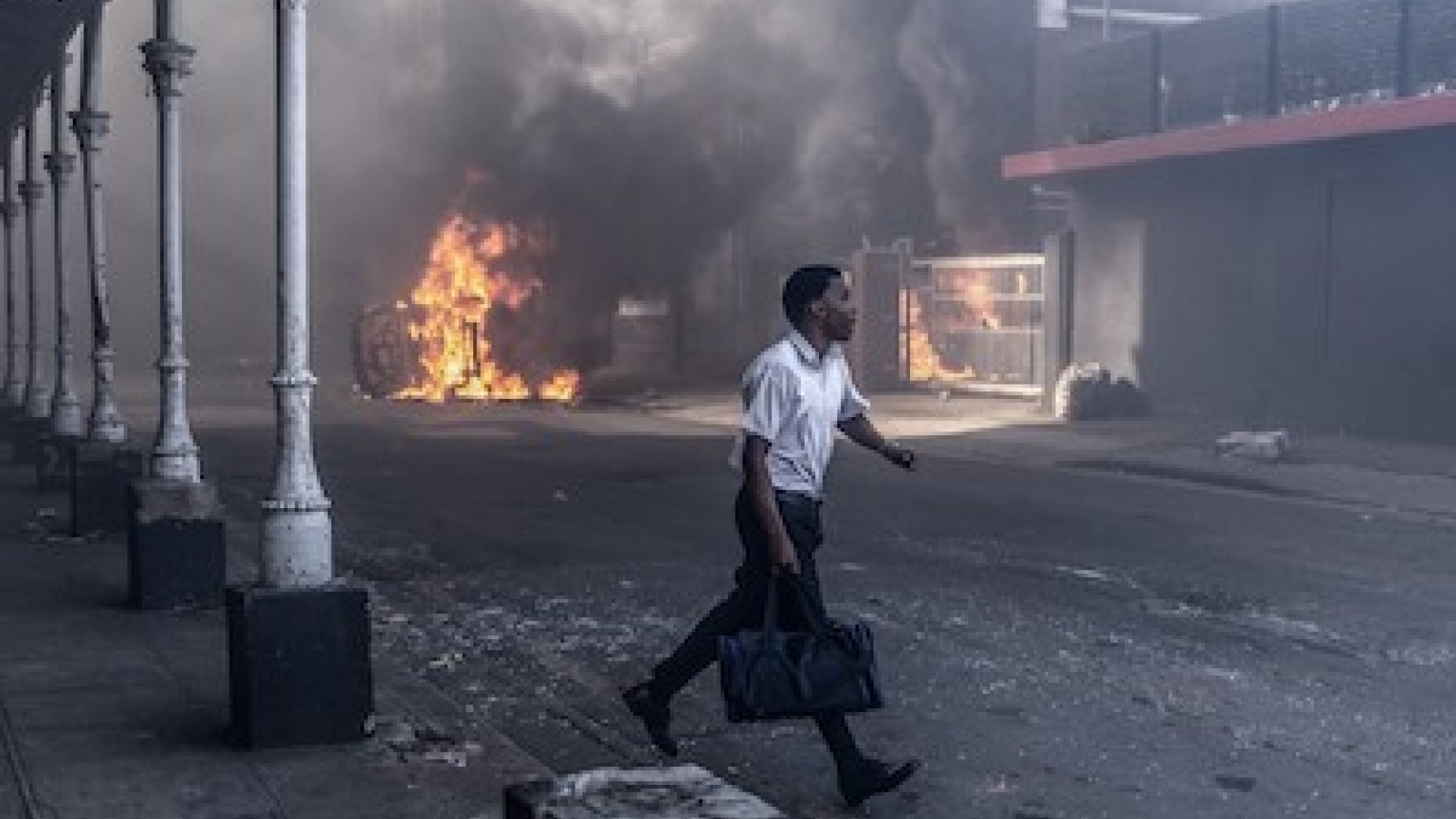 A man runs for cover after clashes erupt between protesters and foreign nationals in Durban on October 8, 2026.