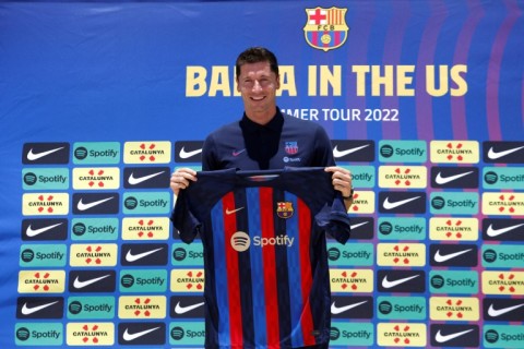 If the cap fits: Robert Lewandowski about to try on a Barcelona shirt after joining the club in July