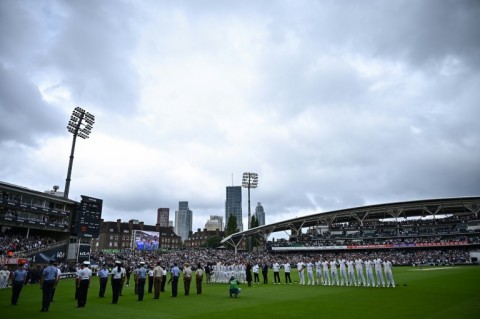 England (R) and South African cricketers (REAR/L) wear black armbands as they observe a minute's silence with an honour guard of British Armed Forces personnel (L) following the death of Britain's Queen Elizabeth II, ahead of Saturday's play in the third Test at the Oval