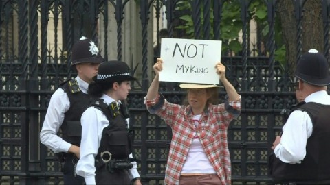 The protester was led away by four police officers