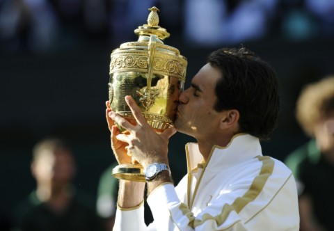 Marathon man: Federer kisses the trophy after his five-set win over Andy Roddick in 2009