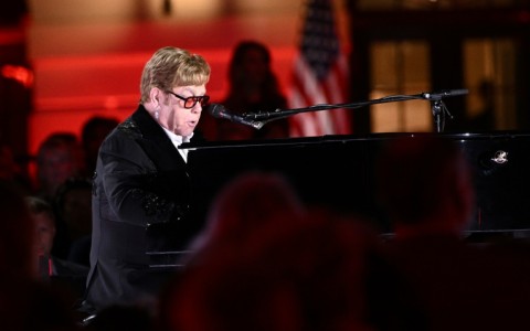 Dressed in a glittering black suit and wearing orange glasses, the 75-year-old pop icon sat down at the piano on the South Lawn of the White House