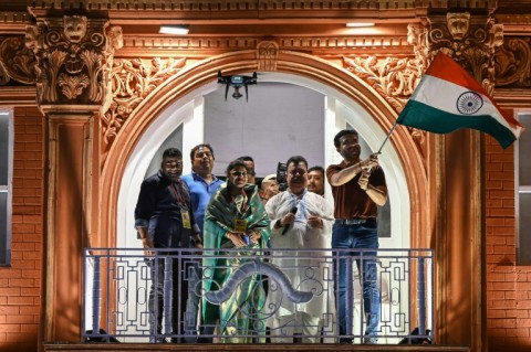 Former Indian cricket captain Sourav Ganguly, right, waves the flag of India during the inauguration of a replica balcony of the Lord's Cricket Ground in London 