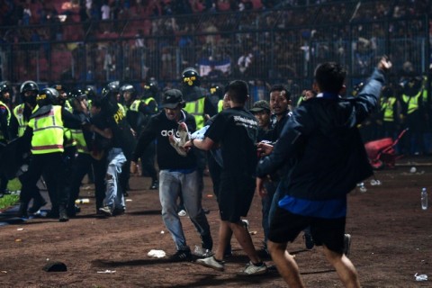 Tragedy: A fan is carried off the pitch 