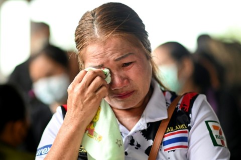 Families gather outside a Thai nursery where an ex-policeman murdered nearly two dozen children