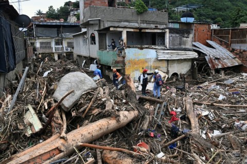 Rescuers and residents search through the rubble for victims or survivors of the landslide in Las Tejerias