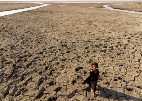 A child walks on the dried-up bed of Iraq's receding southern marshes of Chibayish in Dhi Qar province on August 23, 2022