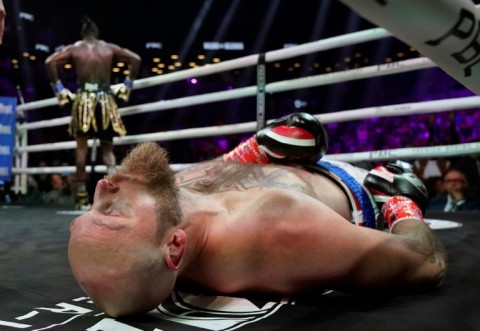 Former world heavyweight champion Deontay Wilder, left, poses moments after knocking out Finland's Robert Helenius, front, in the first round of their fight in New York