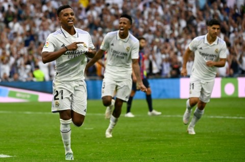 Real Madrid's Brazilian forward Rodrygo (L) celebrates after scoring his team's third goal against Barca