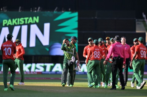 Pakistan's Shan Masood and Shadab Khan (C) walk off the field after their win over Bangladesh