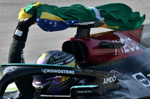 Lewis Hamilton celebrates with a Brazilian flag after winning in Brazil last year 
