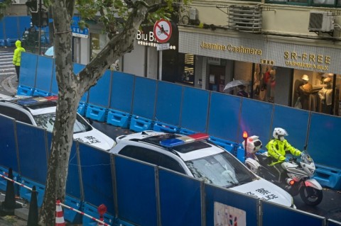 Police vehicles are seen next to Wulumuqi road in Shanghai two days after rare protests against China's zero-Covid policy 