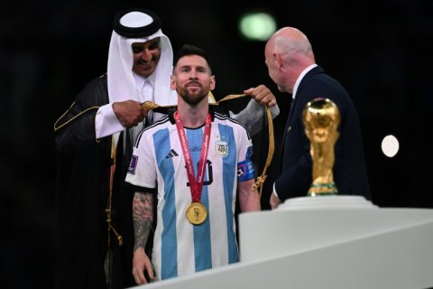 Honour: Qatar's Emir Sheikh Tamim bin Hamad al-Thani presents Lionel Messi with a traditional cloak after winning the World Cup