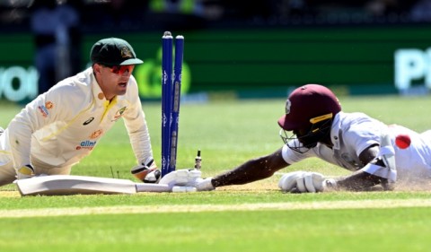 Australia's wicketkeeper Alex Carey (L) runs out West Indies batsman Anderson Phillip