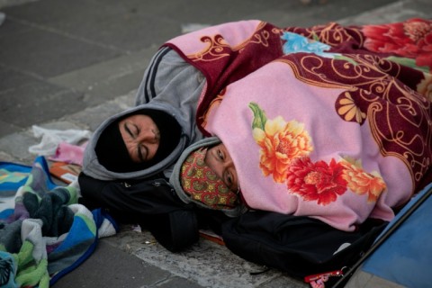 Pilgrims sleep on the ground outside the shrine