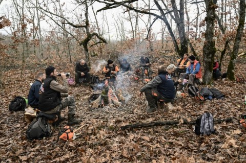 A group of lumberjacks take a rest around a woodfire in a forest in northern Greece
