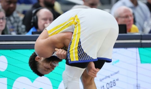 Golden State's Stephen Curry grimaces after suffering a left shoulder injury in the third quarter of the Warriors' 125-119 loss at Indiana 