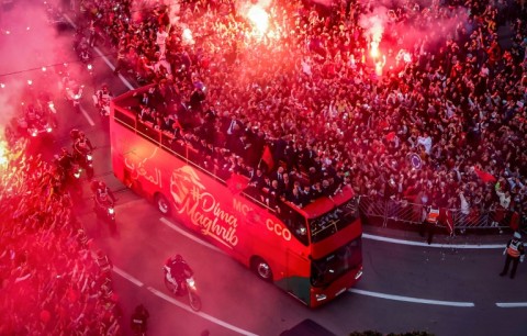 Supporters light flares and cheer as Morocco's national football team travels through the capital Rabat