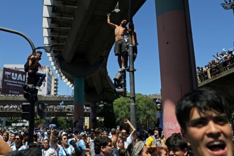 Fans wait for the bus with Argentina's players to pass by in Buenos Aires after winning the Qatar 2022 World Cup tournament