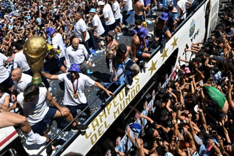 Fans of Argentina cheer in Buenos Aires as the team parades on board a bus after winning the Qatar 2022 World Cup tournament