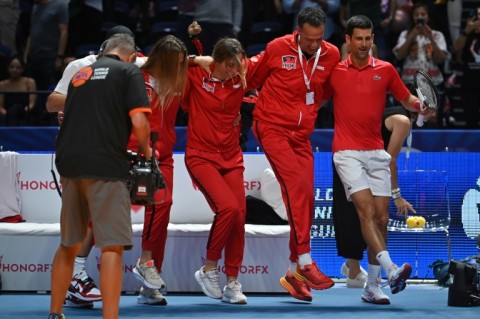 In perfect step: Novak Djokovic (right) celebrates with his teammates after victory in Dubai on Friday