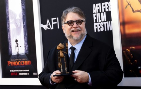 Mexican director Guillermo del Toro holds a wooden puppet as he arrives for the premiere of 'Pinocchio' during the 2022 American Film Institute Festival in Hollywood
