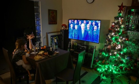 A family watches the televised New Year  address by Russian President Vladimir Putin in Moscow