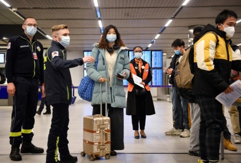 Passengers wait for their vaccination documents to be checked after arriving at Paris's Charles de Gaulle hub after France introduced random testing