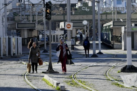 Tunisians are pictured next to a tram station in the capital Tunis during a public transport employee strike on Monday