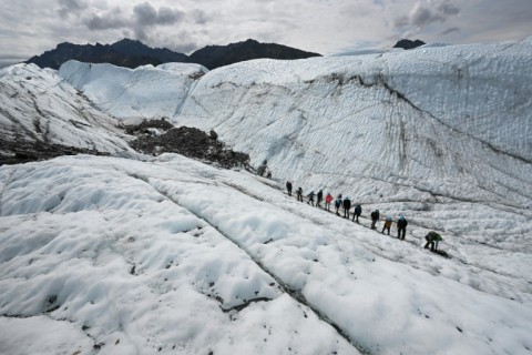 Visitors hike on the ice during a guided tour of the Matanuska Glacier near Palmer, Alaska in July 2022
