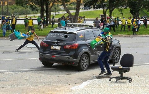 Protesters hurl rocks at a police vehicle outside Planalto Palace in Brasilia on January 8, 2023