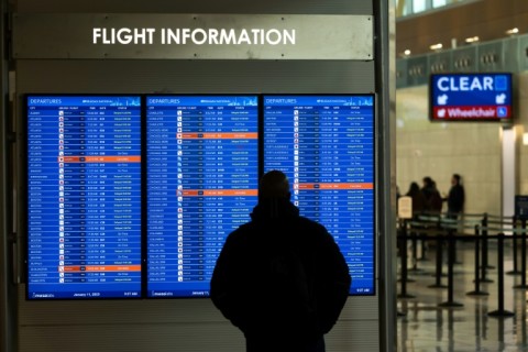 A traveler looks at a display listing cancelled and delayed flights at Ronald Reagan Washington National Airport in Virginia on January 11, 2023