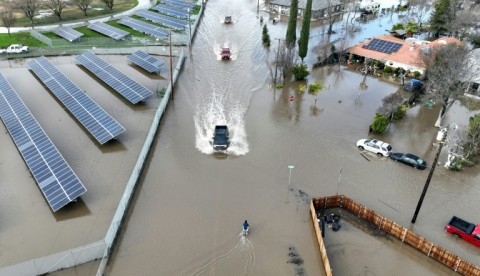Cars driving through a flooded roadway in Planada, California, as an "atmospheric river" continues on January 10, 2023