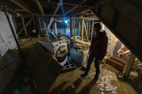Amberlee Galvin looks at the damage to her house from the third flood in two weeks in the California town of Felton