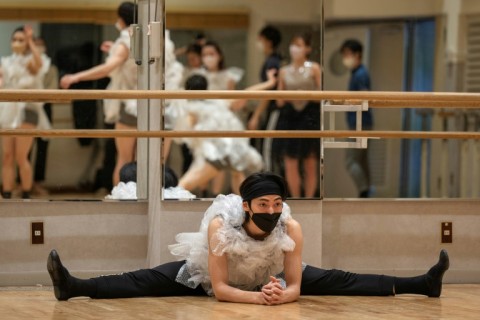 A performer stretches during a rehearsal for the "Vinyl Umbrella Komachi", part of a performance entitled "Plastic" to highlight the issue of plastic pollution, at the K-BALLET dance company studios in Tokyo. 