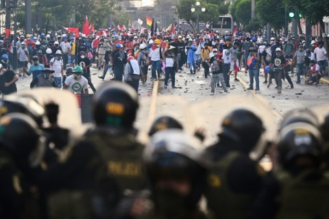 Demonstrators clash with riot police during a protest in Lima on January 24, 2023