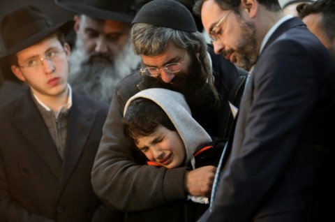 Aharon Natan, the father of 14-year-old Asher Natan, a victim of a shooting attack in east Jerusalem on January 27, 2023, mourns with her other son during his funeral at a cemetery in Jerusalem, on January 29, 2023