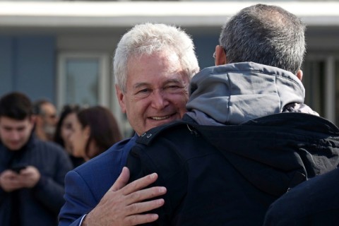 A supporter greets presidential candidate Andreas Mavroyiannis after he cast his vote at a polling station in Nicosia