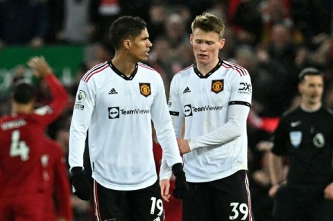 Manchester United's Raphael Varane (L) and Scott McTominay react to their historic defeat at Liverpool