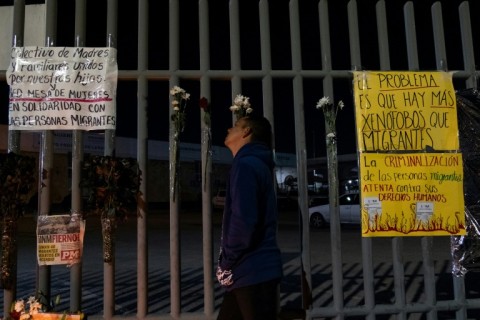 Migrants left candles and flowers during a vigil outside the detention center, demanding better treatment by the authorities