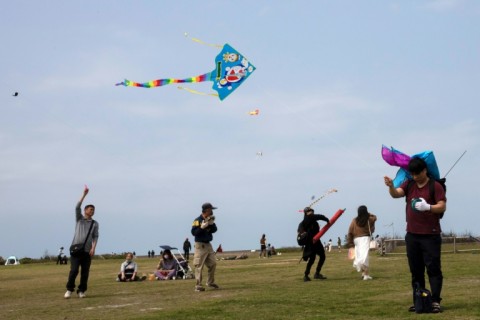 People fly kites near Taiwan's Hsinchu fishing port 