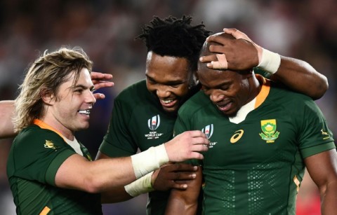 Springboks Faf de Klerk (L) and Lukhanyo Am (C) congratulate try scorer Makazole Mapimpi during the 2019 Rugby World Cup final against England in Yokohama.
