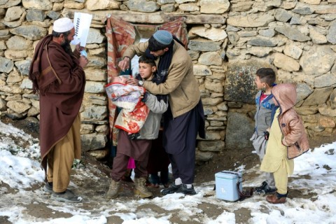 An Afghan health worker administers polio vaccine drops to a child during a campaign in the Dara-i-Nur district of Nangarhar province