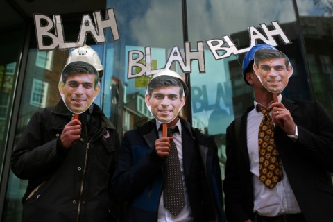 Protesters hold up masks of Britain's Prime Minister Rishi Sunak in London