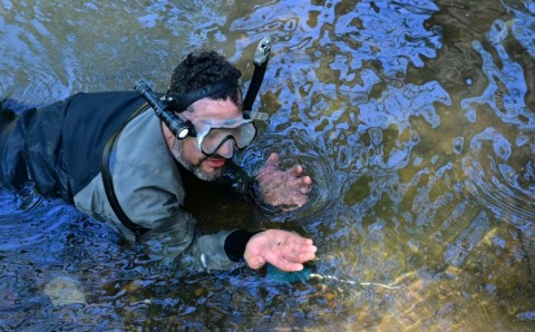 Albert Fausel holds a tiny piece of gold found in a creek in Placerville, California -- recent torrential rains have been kind to gold hunters