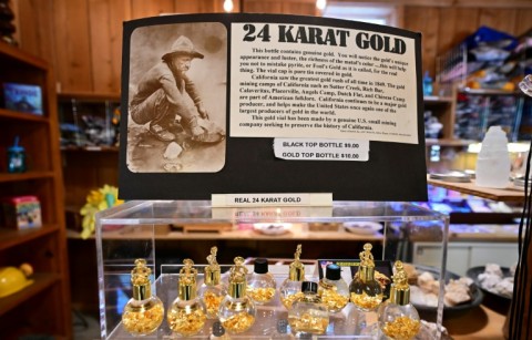 The history of gold in the region is explained on a sign above gold trinkets for sale from the gift shop at the Gold Bug Mine Museum in Placerville, which relies on tourism themed around its golden history