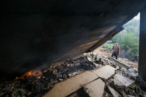 A Palestinian man looks at a destroyed building in Deir el-Balah, Gaza