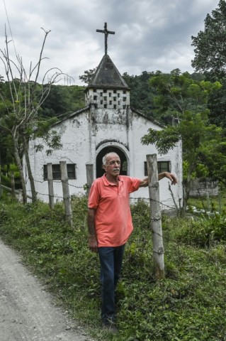 William Suarez, a survivor of the last big erruption of Nevado del Ruiz volcano, stands in front of the church of the Rio Claro village in Villamaria, Colombia