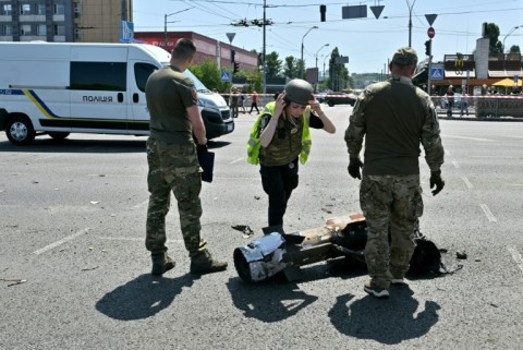 Police experts examine fragments of a missile after Russia launched an unusual daytime attack on Kyiv
