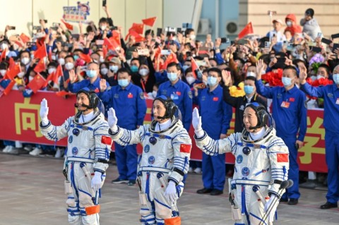 Gui Haichao (L) payload expert, Zhu Yangzhu (C) space flight engineer and commander Jing Haipeng (R) wave during the seeing-off ceremony for the Shenzhou-16 mission to China's space station